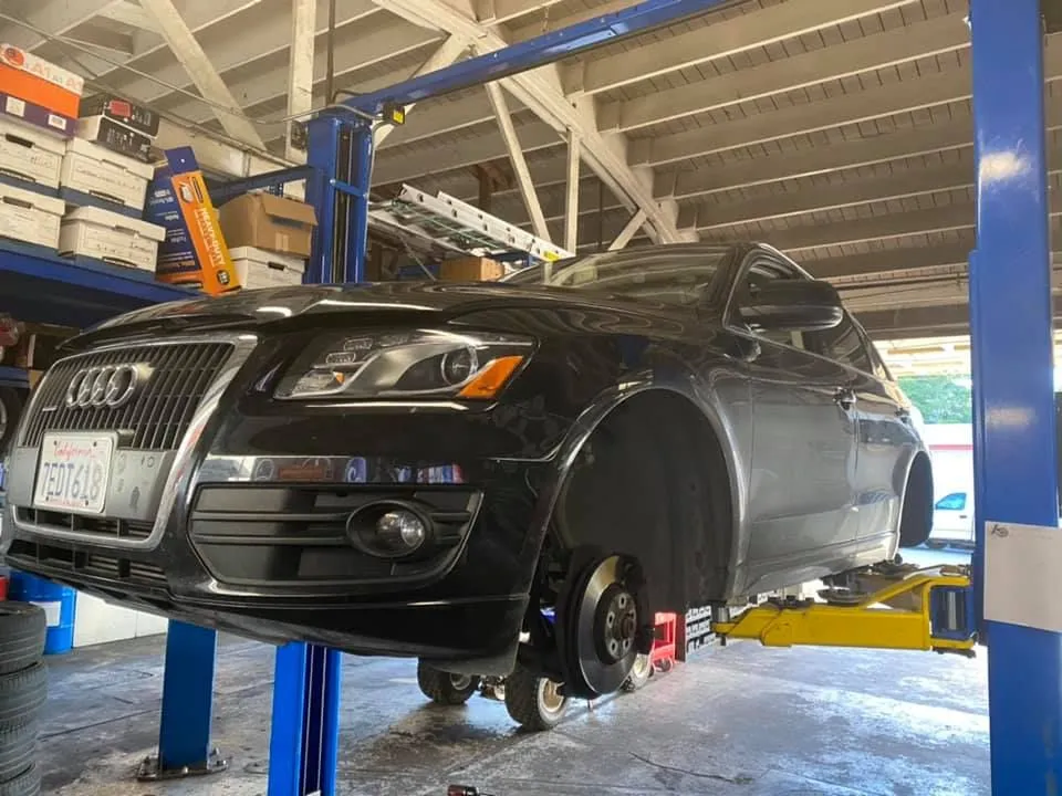 Black Audi SUV raised on a lift in a repair shop, wheels removed. | Golden Gear Automotive