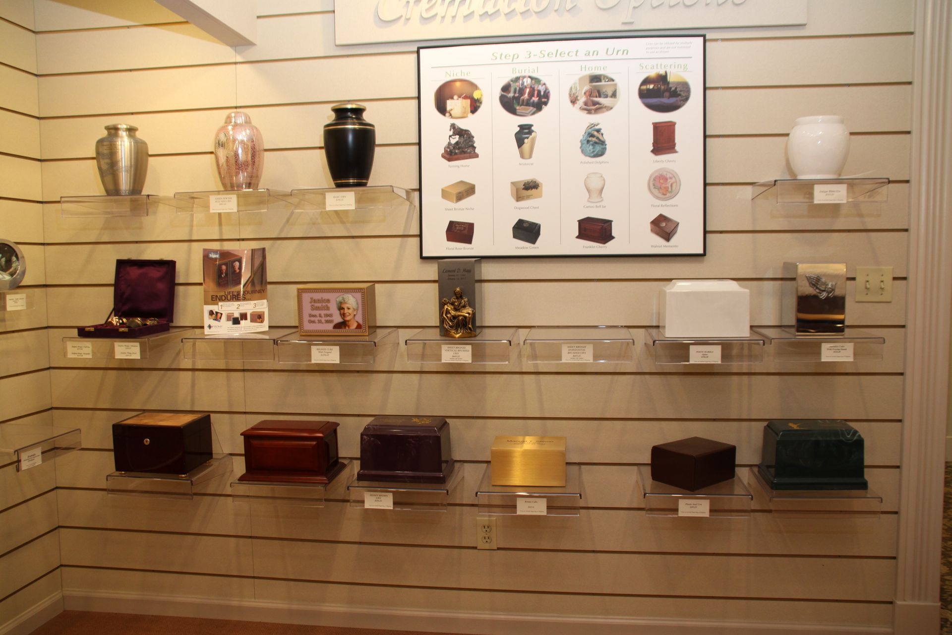 Wall display of decorative urns, vases, and small boxes on shelves in a showroom.