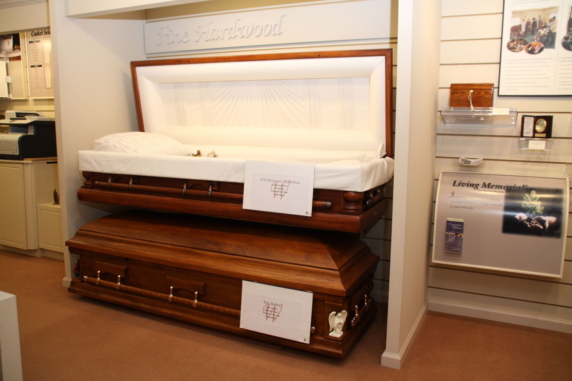 Open coffin display in a showroom, with white lining and brown wood finish