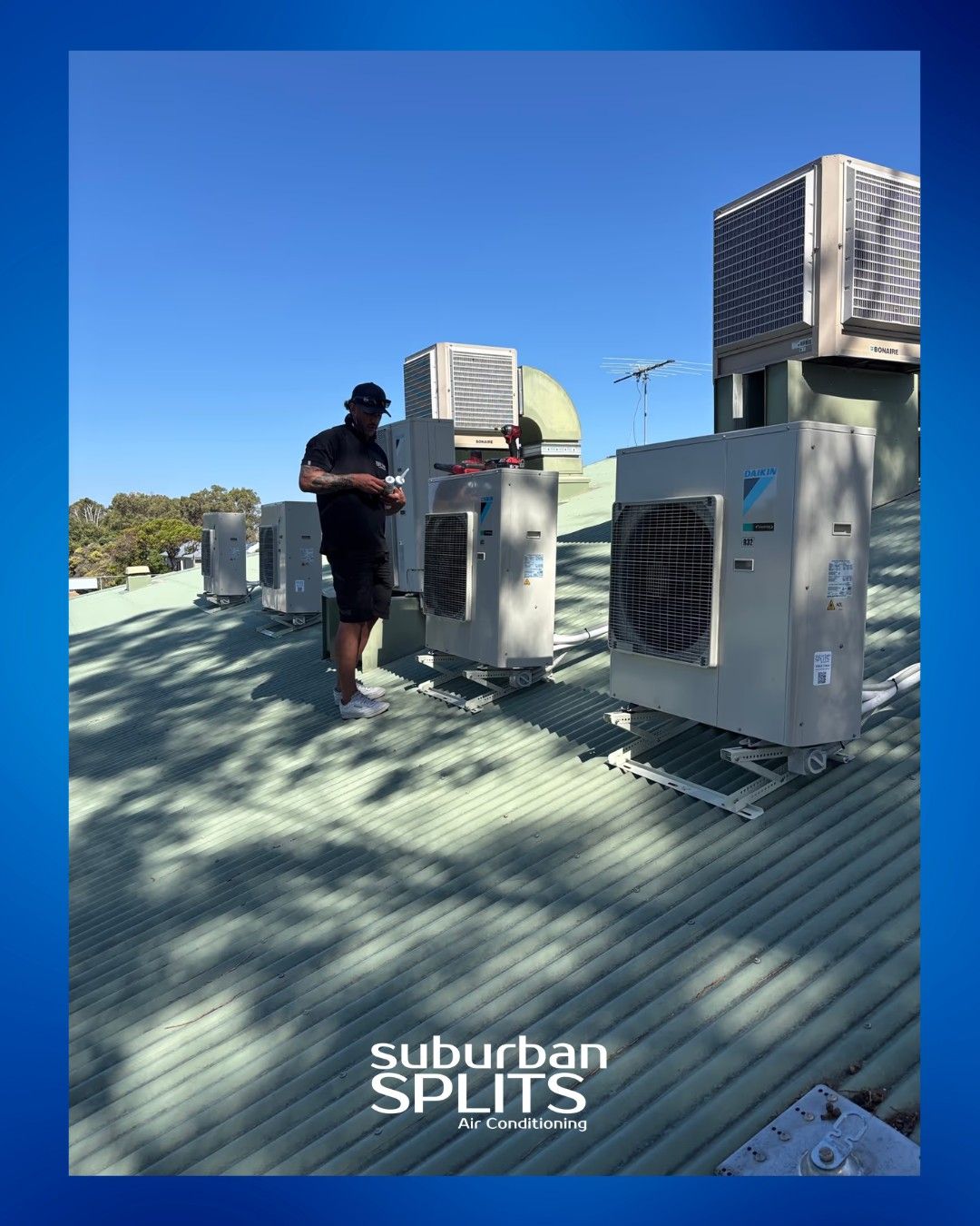 Man on a rooftop with several air conditioning units; clear blue sky— Canobolas Air in Orange, NSW