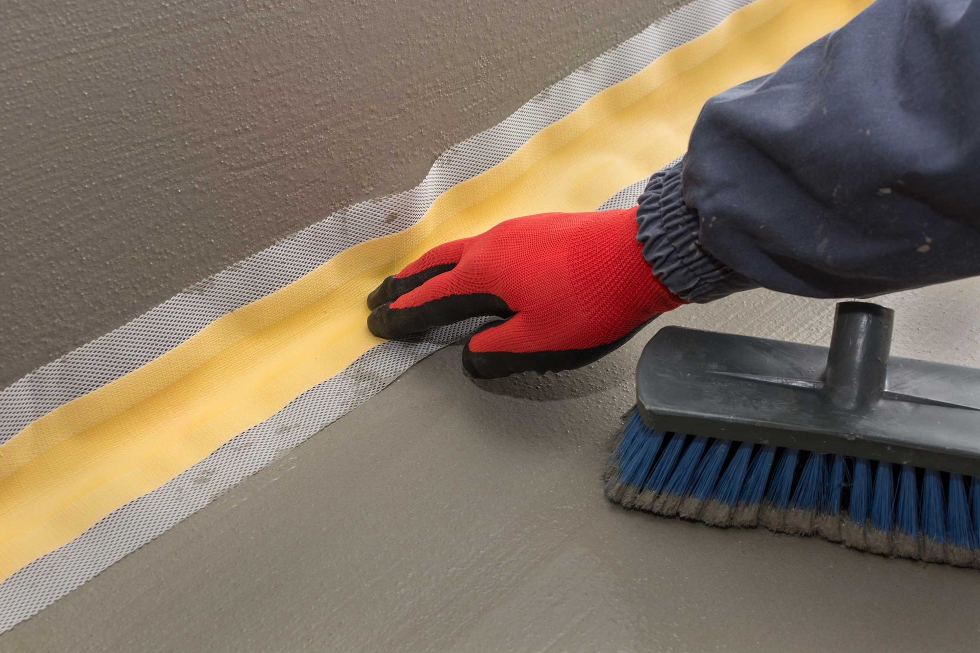 Applying seal and membrane for basement waterproofing.