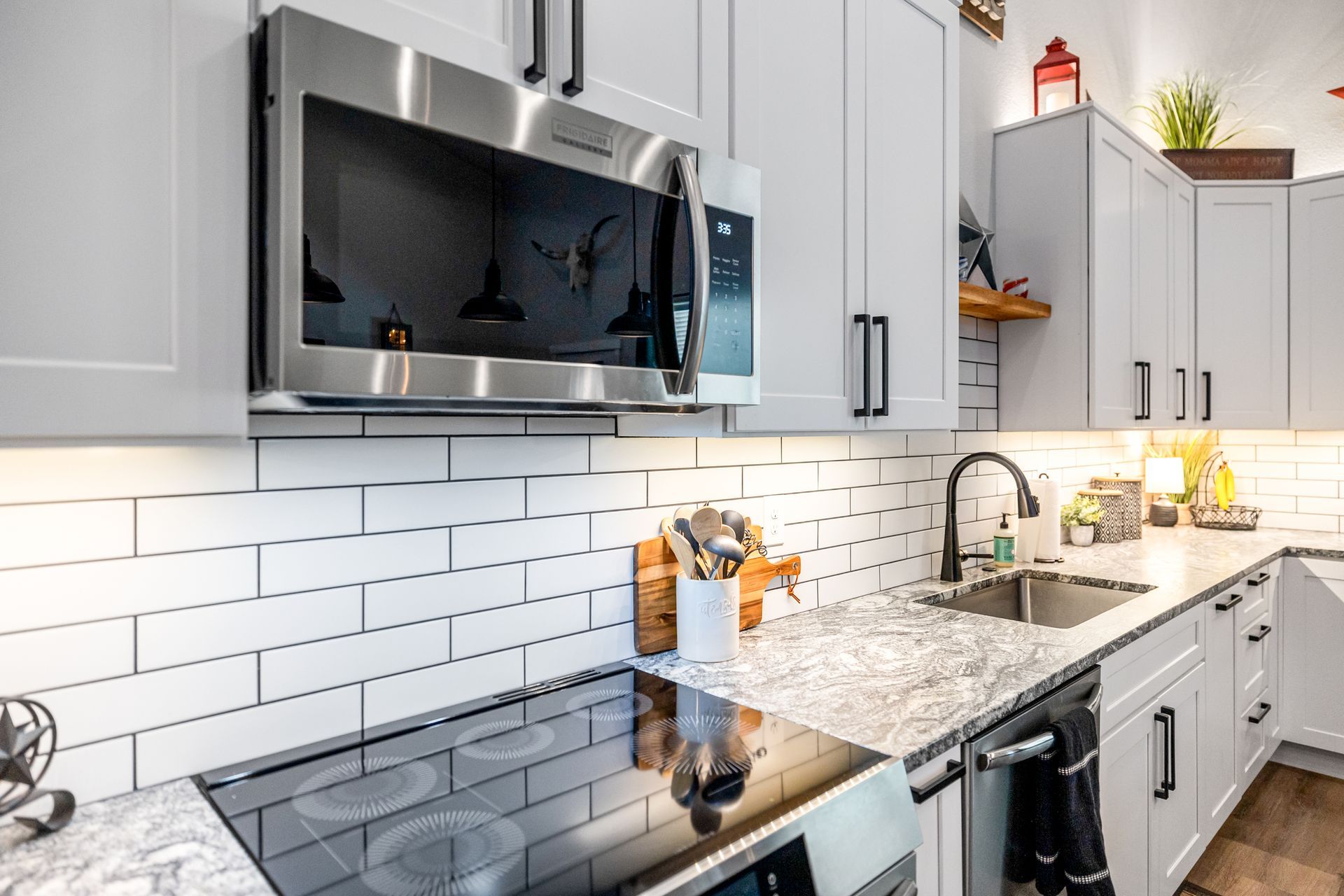 Modern kitchen with stainless steel appliances, white subway tile backsplash, and granite countertops