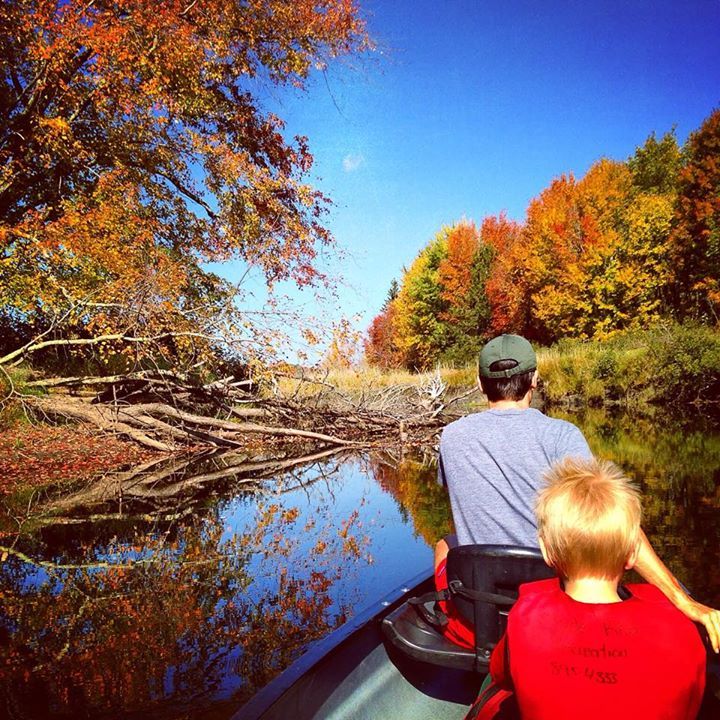 A man and his son kayak down Clyde River in Vermont during a Clyde River Recreation paddle trip