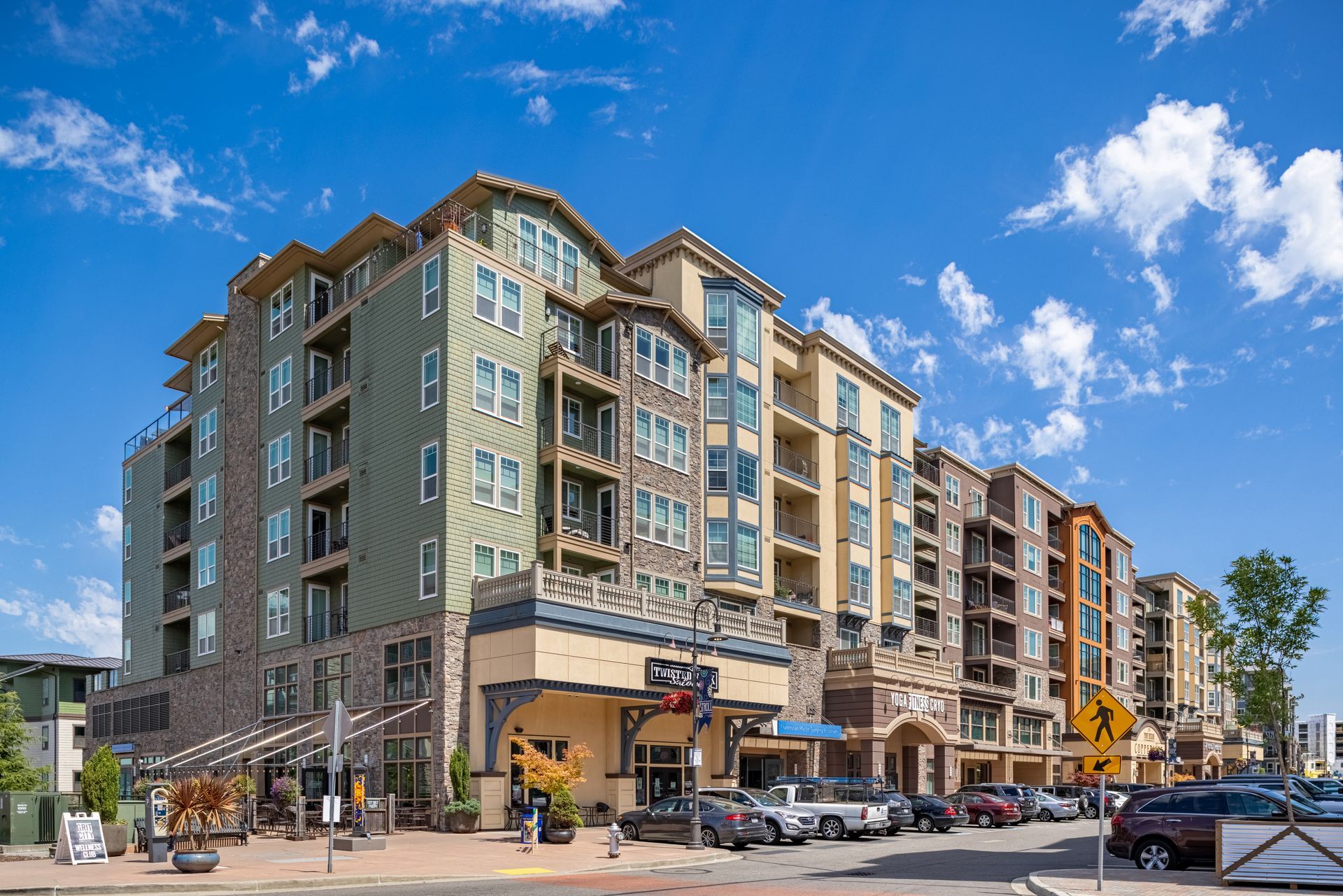 Modern apartment building with storefronts on a sunny street under a blue sky at Copperline at Point Ruston in Tacoma, WA.