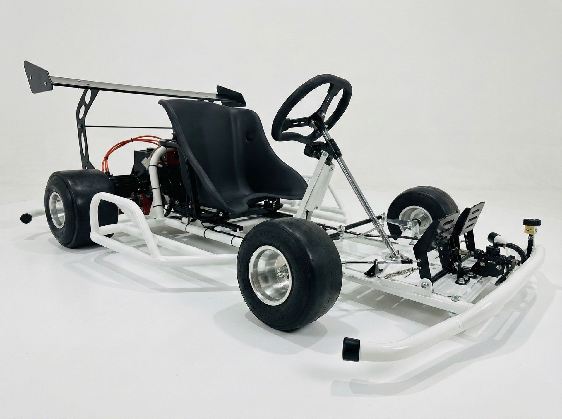 White go-kart chassis with black seat and steering wheel on a plain white background