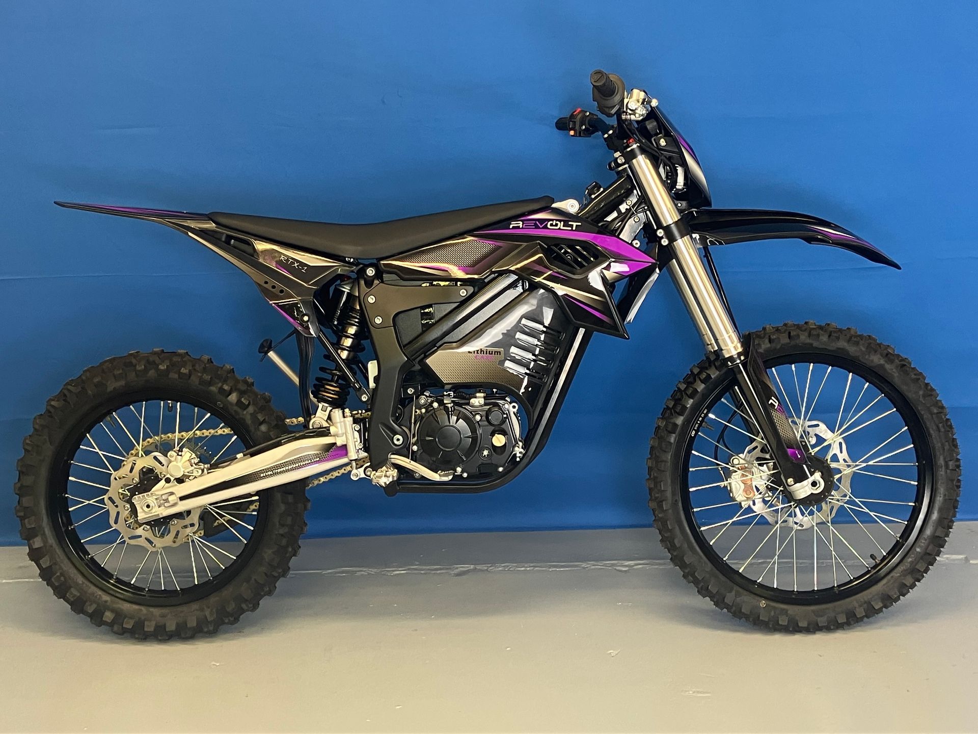 Black and purple dirt bike on a stand against a blue background