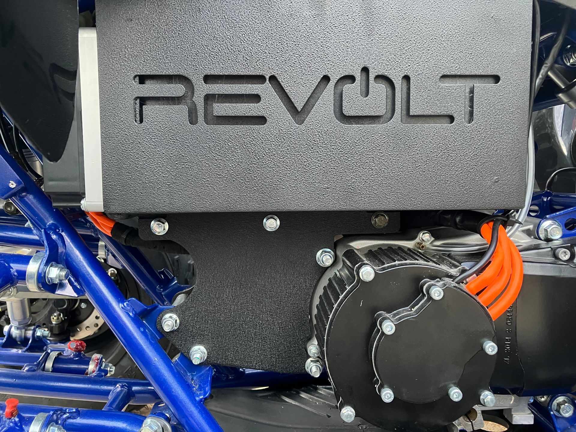 Close-up of a Revolt electric motor and orange cables inside a blue-framed vehicle chassis