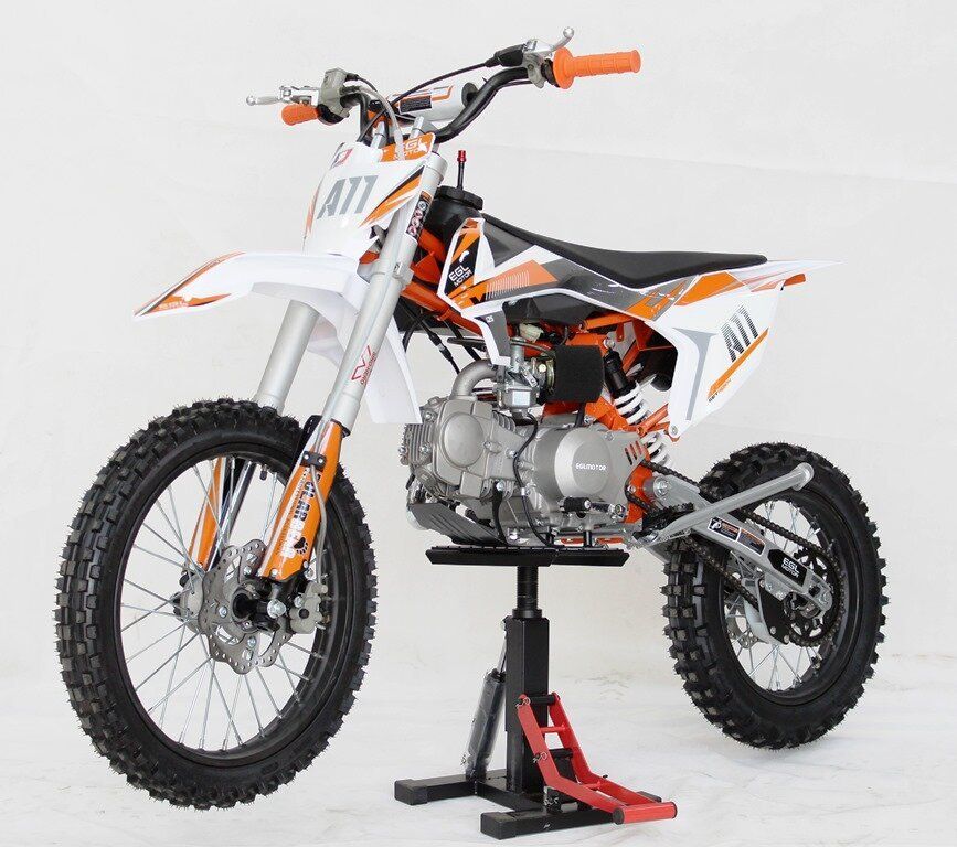 Orange-and-white dirt bike on a stand against a white studio background