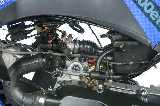 A close up of the engine of a motorcycle on a white background.