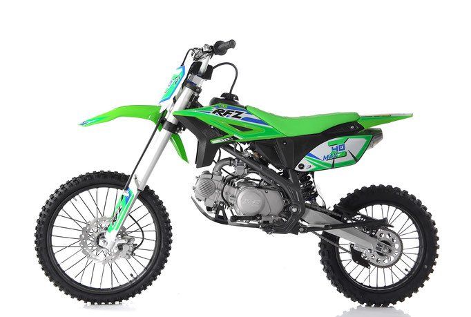 Green and black dirt bike on a white background, shown from the side.