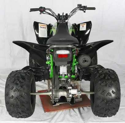 A black and green atv is sitting on a white surface