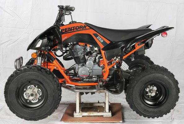Orange and black ATV with oversized tires on a display stand