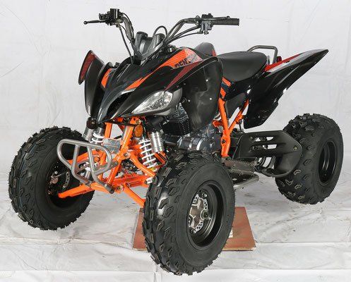 Black and orange sport ATV with knobby tires, shown in a studio on a white backdrop