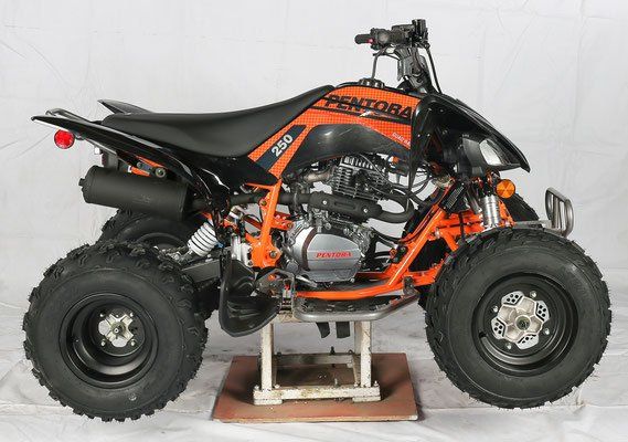 Black and orange ATV on a stand, side view, with large off-road tires and exposed engine.