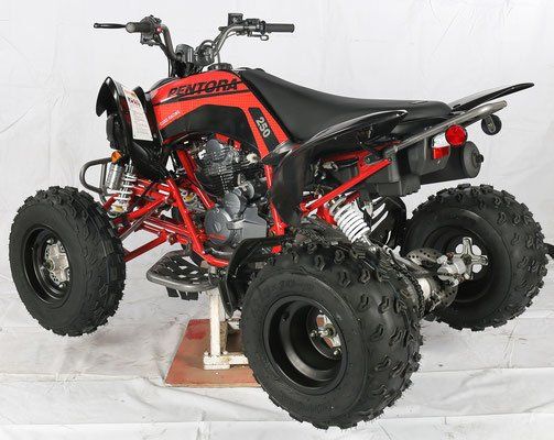 Red and black sport ATV with knobby tires, shown on a stand against a white backdrop.