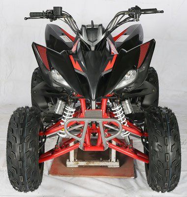 Front view of a black and red ATV with knobby tires and a red frame on a stand