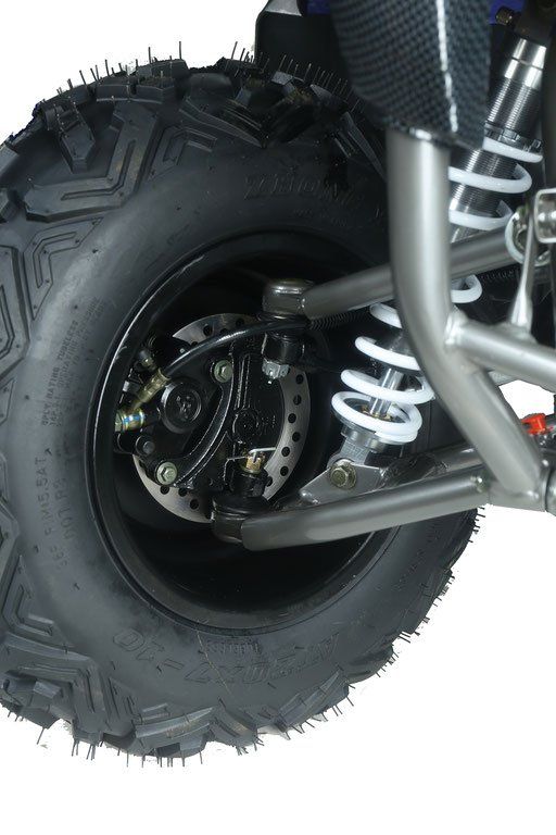 Close-up of a rugged off-road vehicle wheel with thick tire tread and exposed suspension springs