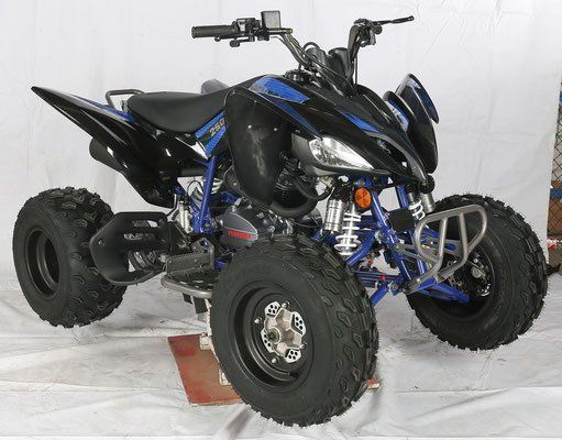Black and blue sport ATV with wide rear tires, shown in a studio on a white backdrop