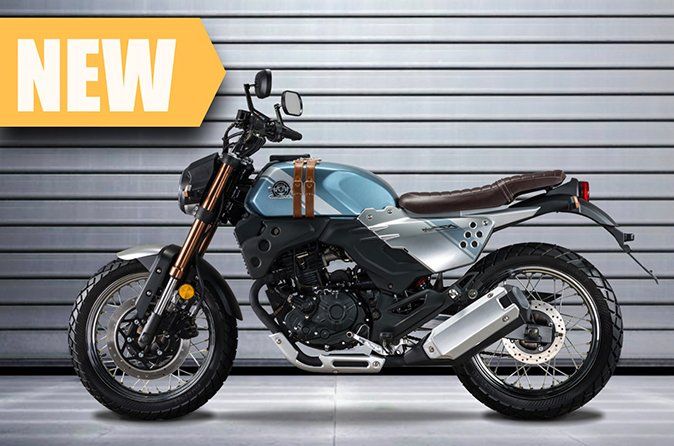 A new motorcycle is parked in front of a garage door.