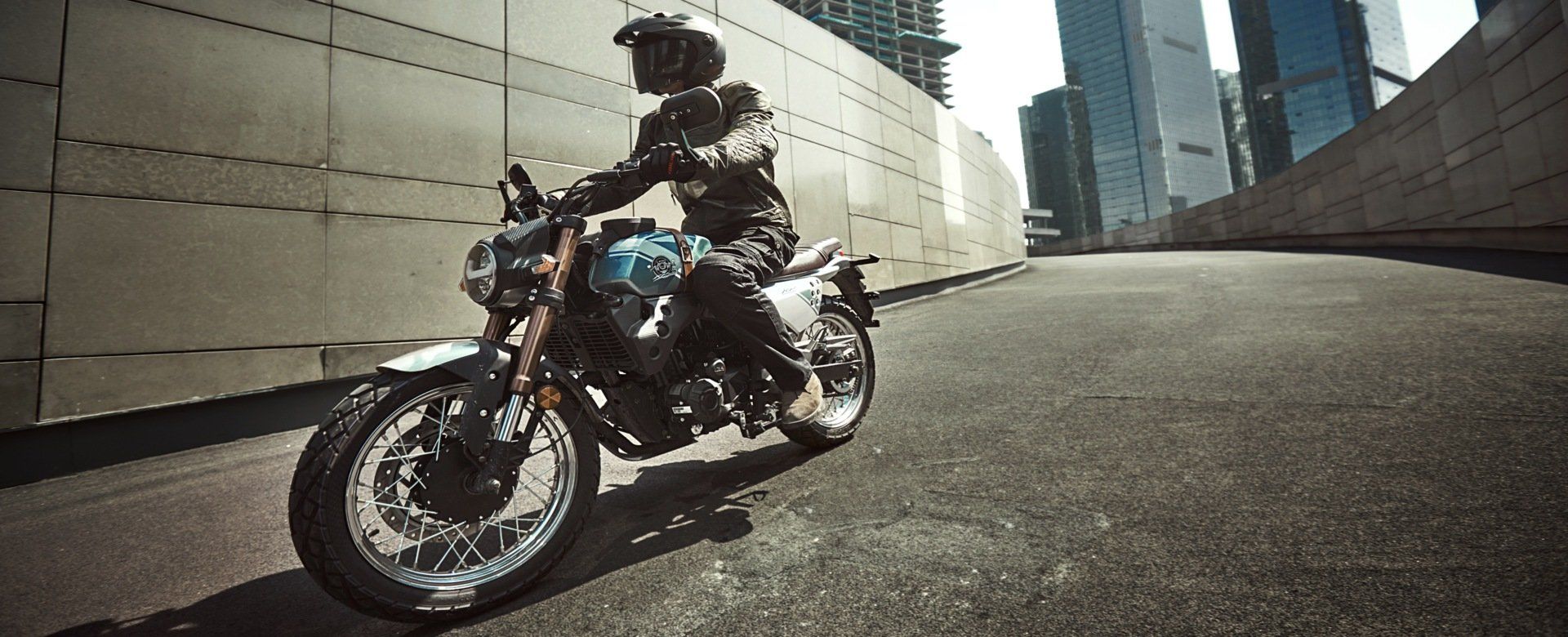 A man is riding a motorcycle down a city street.