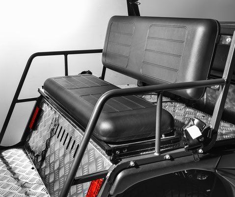 Black cushioned bench seat with metal armrests on a utility vehicle.