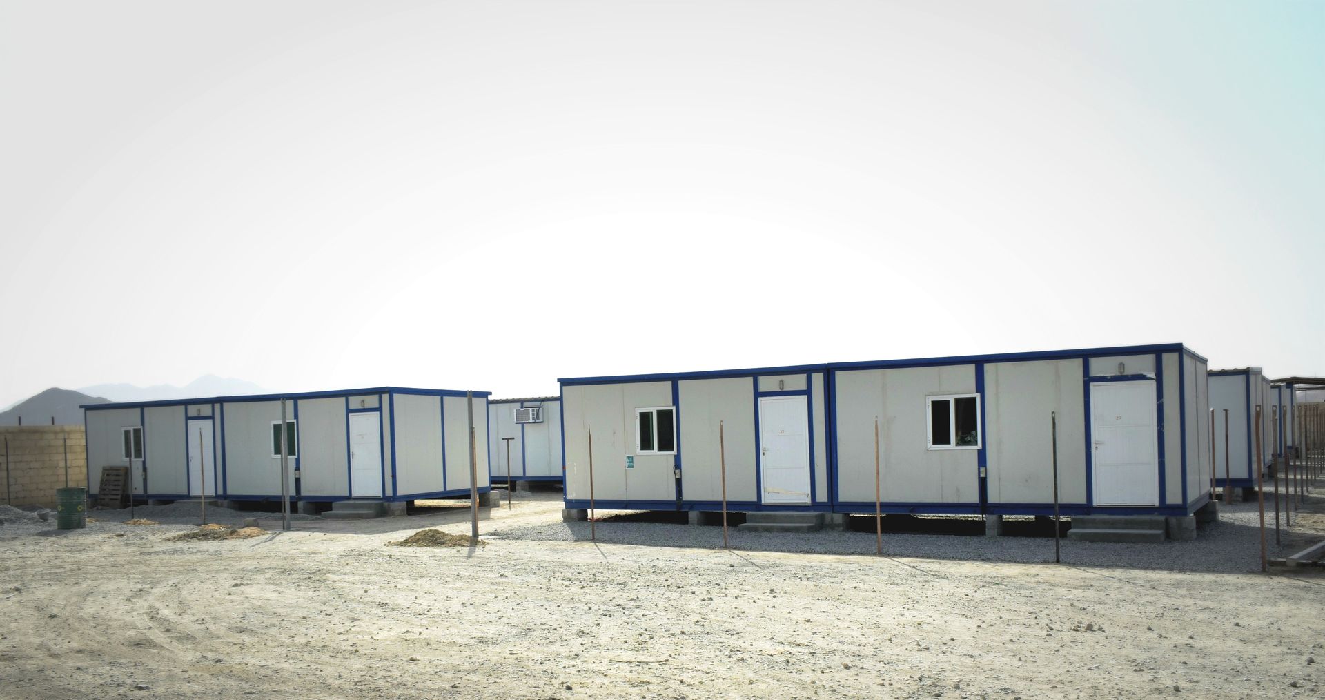 Multiple mobile storage containers arranged on a gravel lot, commonly used for temporary workspace or storage. Multiple mobile storage containers arranged on a gravel lot, commonly used for temporary workspace or storage.