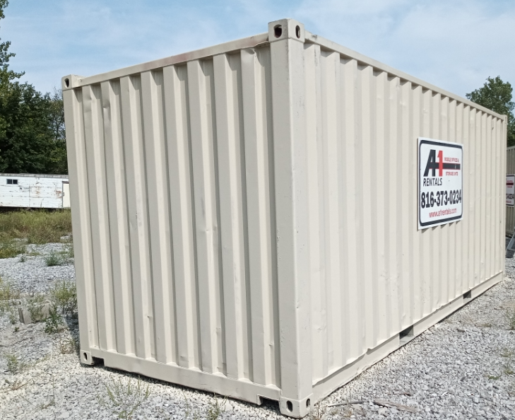 A tan corrugated steel shipping container sits on a gravel lot under a bright sky A tan corrugated steel shipping container sits on a gravel lot under a bright sky