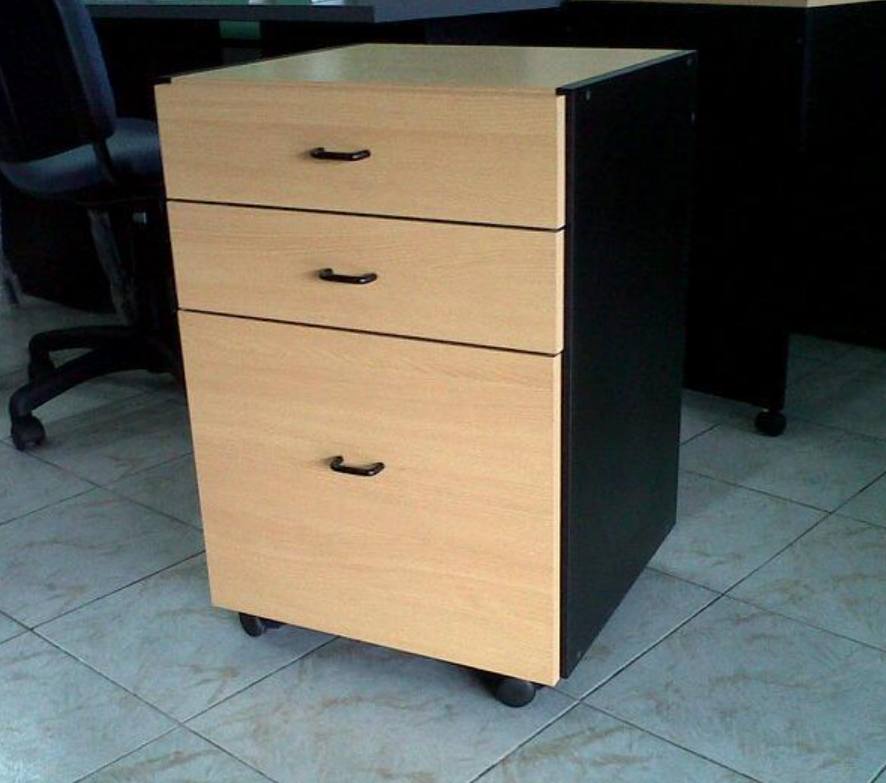 Archivador pequeño de oficina, de color beige y negro, con tres cajones con ruedas, en una habitación alicatada.