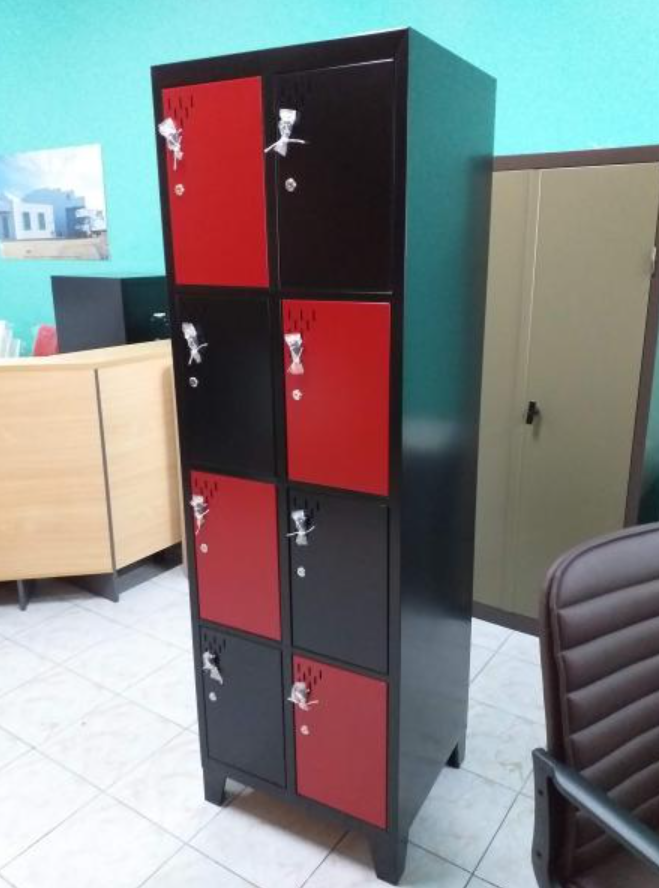 Armario negro y rojo en una oficina con suelo de baldosas y sillas cerca.