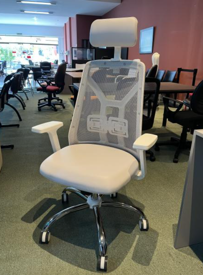 Silla de oficina blanca de malla con reposacabezas en una sala de conferencias con mesas y otras sillas.