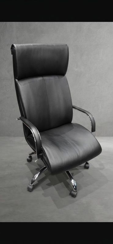 Silla de oficina blanca de respaldo alto con brazos cromados y base de cinco ruedas sobre fondo gris claro.