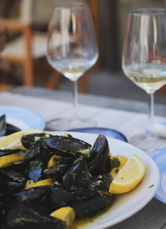 Piatto di gamberi fritti, anelli di calamari e frittelle di mais con salsa e spicchio di limone.