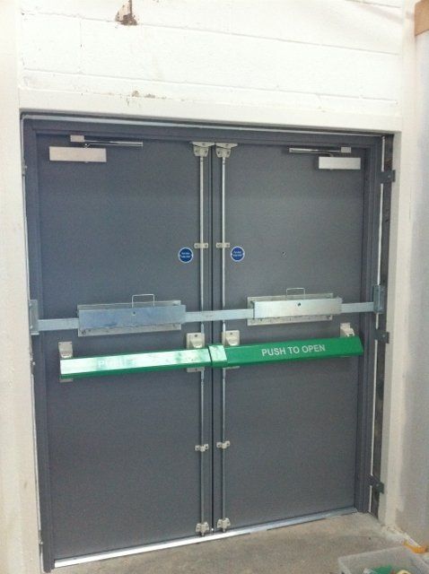 A door with a green push to open bar on it