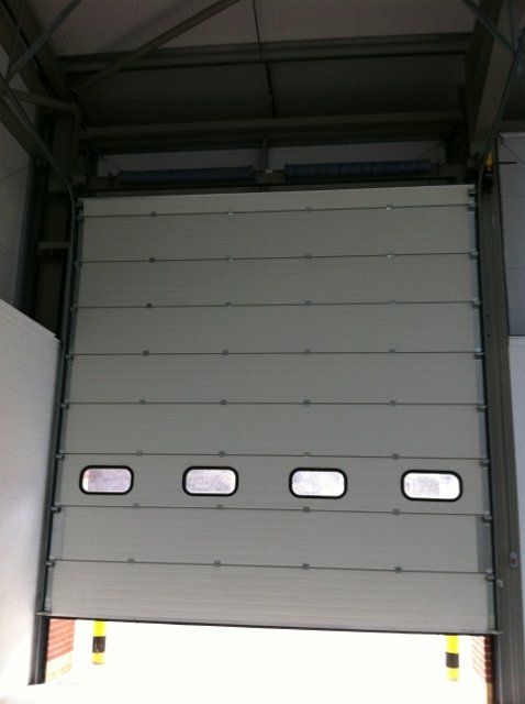 A white garage door with four windows on it