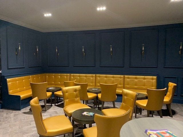 A room with yellow chairs and tables and blue walls.