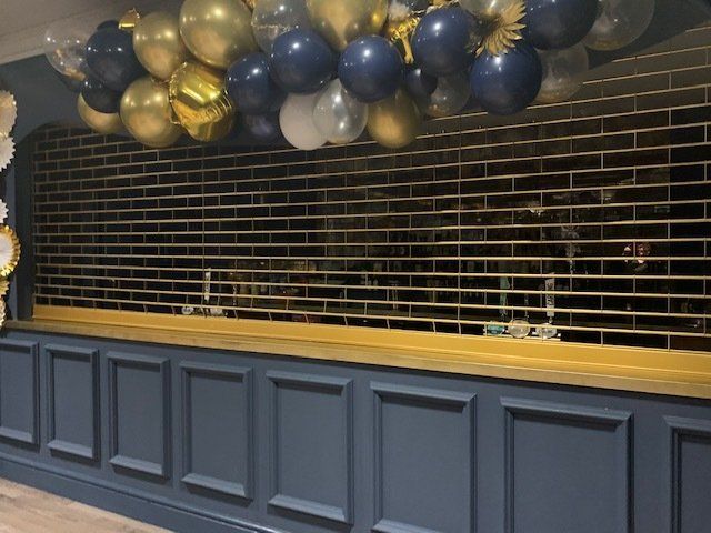 A bunch of balloons are hanging from the ceiling in a room.