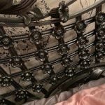 A close up of a wrought iron headboard on a bed.