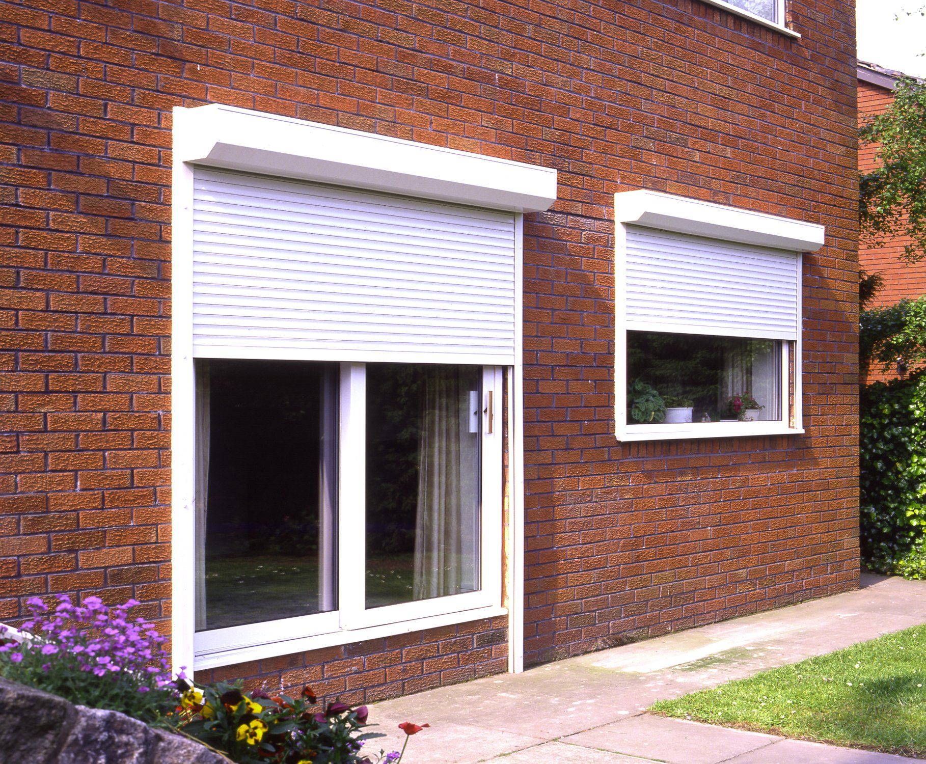 A brick building with white shutters on the windows