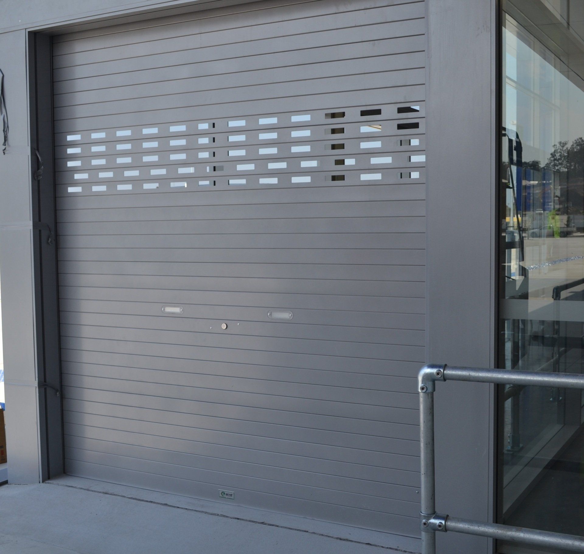 A gray garage door with holes in it