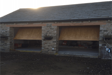 A brick building with two garage doors that are open
