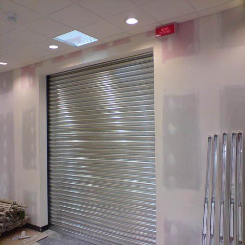 A roller shutter door is being installed in a room.