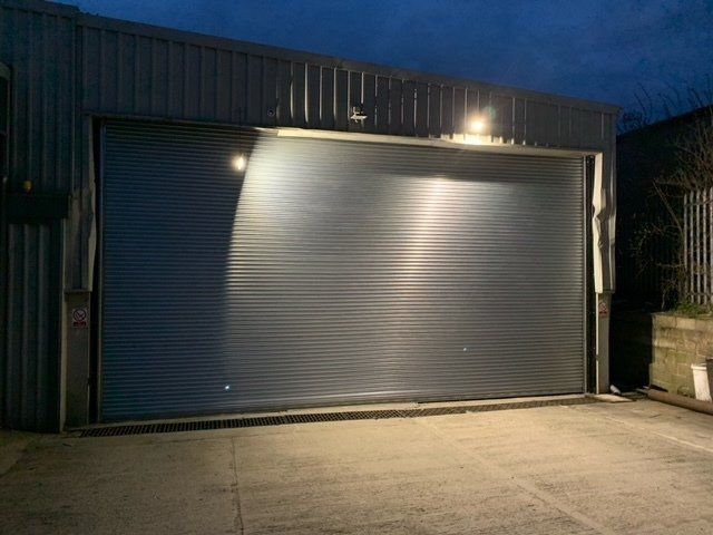 A blue truck is parked in a large warehouse