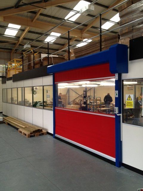 A warehouse with a red door and a blue roof