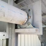A pipe is attached to a metal structure in a building.