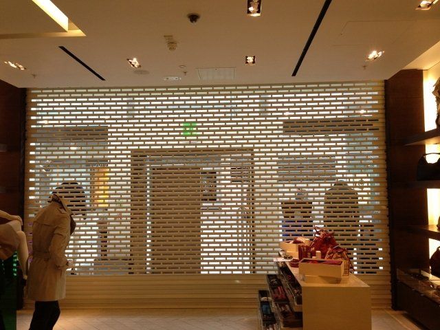 A store with a white brick wall and a green exit sign