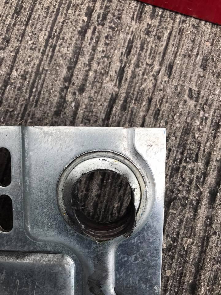 A close up of a metal piece with a hole in it on a wooden surface.