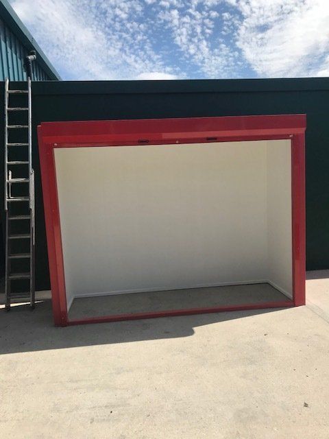A red and white building with a ladder in front of it