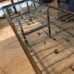 A metal railing is being built in a workshop.
