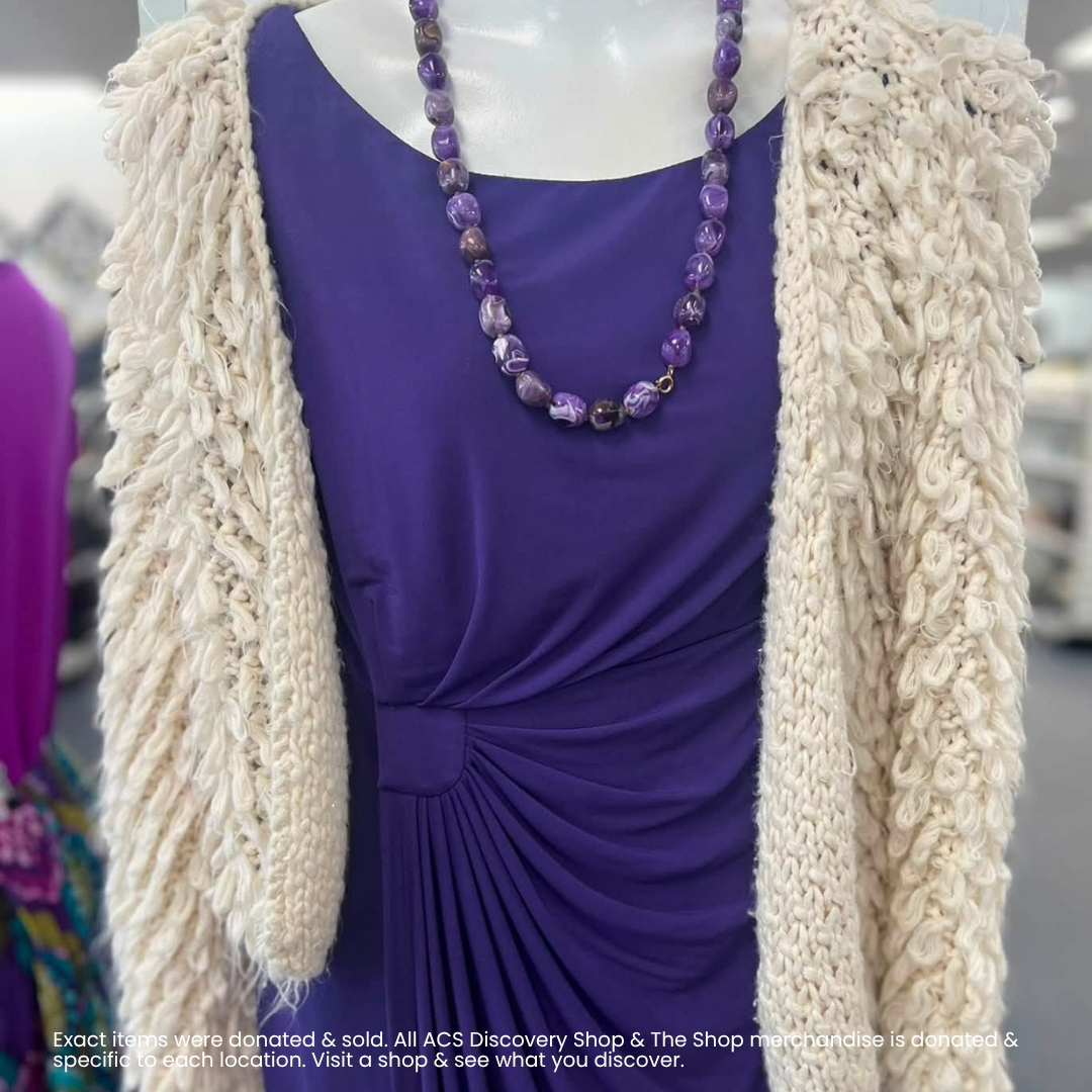 Purple dress with ruched waist and cream shaggy cardigan, styled with a purple beaded necklace.