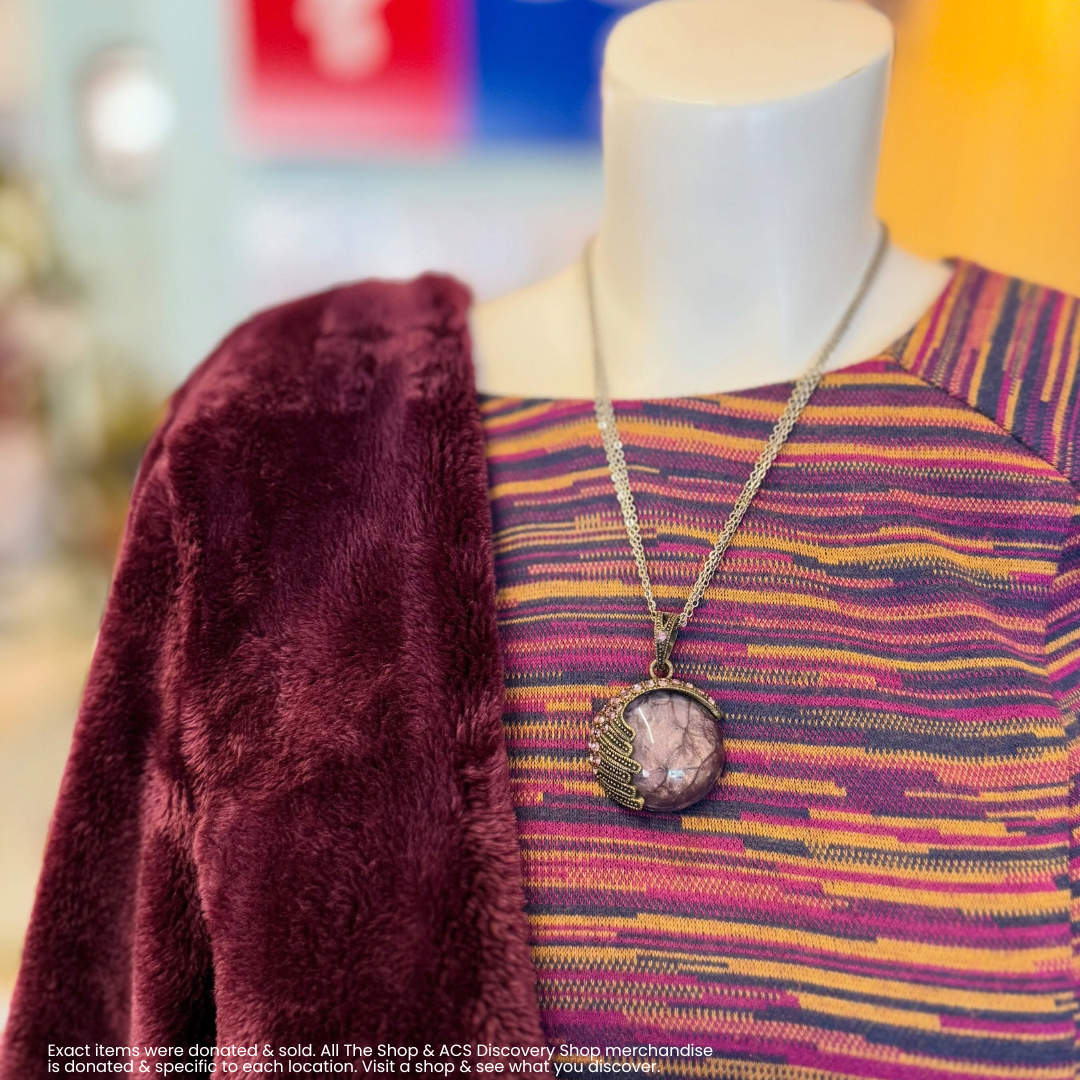 Mannequin in striped top with burgundy shawl and pendant necklace